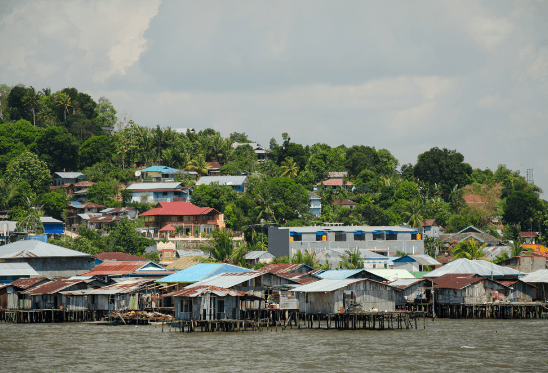 houses sitting just above a river and houses on a hill